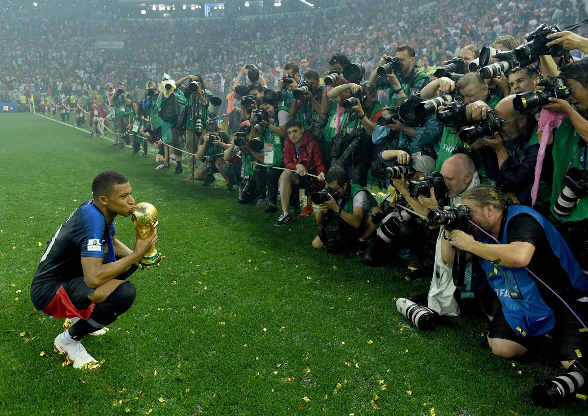 俄罗斯莫斯科 - 7 月 15 日:法国队的基利安·姆巴佩 (Kylian Mbappe) 在 2018 年世界杯决赛中法国队与克罗地亚队在卢日尼基体育场举行的比赛中获胜后,庆祝世界杯奖杯。